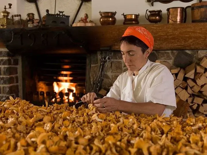 Chef del Ristorante Miola che pulisce finferle freschi davanti al camino
